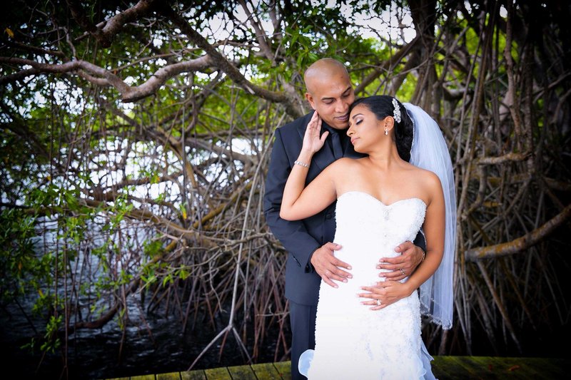 Bride enjoys groom's embrace from behind. Photo by Ross Photography, Trinidad, W.I..