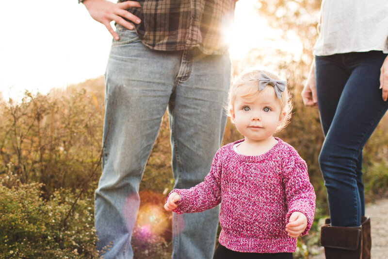 daughter toddler standing between parents during golden hour ohio