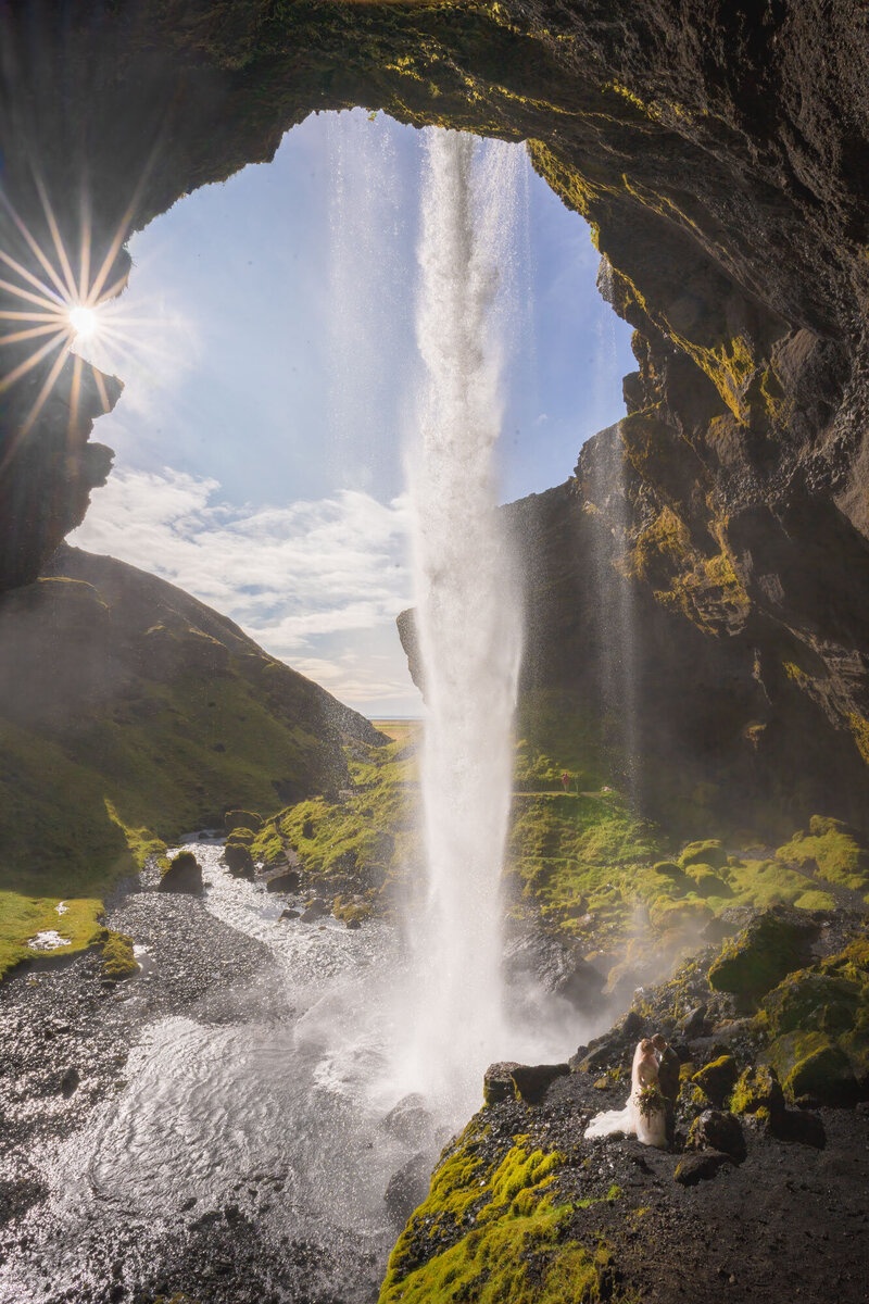 Elopement behind Kvernufoss waterfall in South Iceland with the sun shining through the canyon.