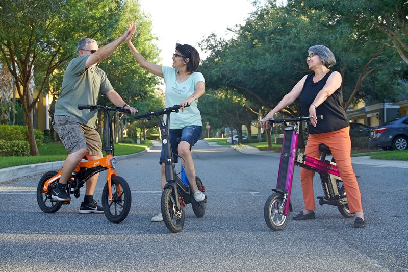 Three friends high fiving after a scenic electric bike ride