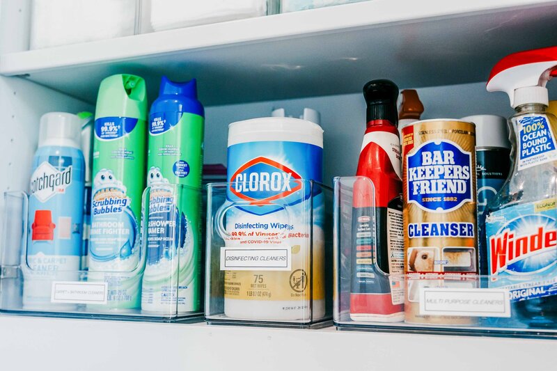 An open cabinet showing organized cleaning products