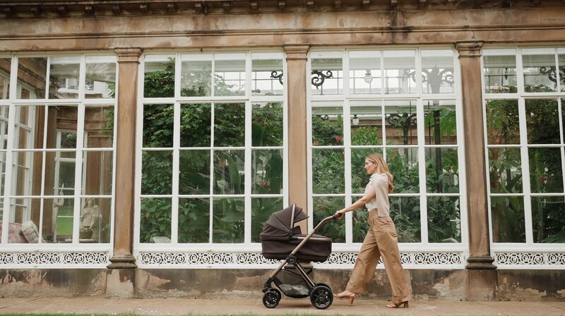 Side view of a lady pushing a stroller
