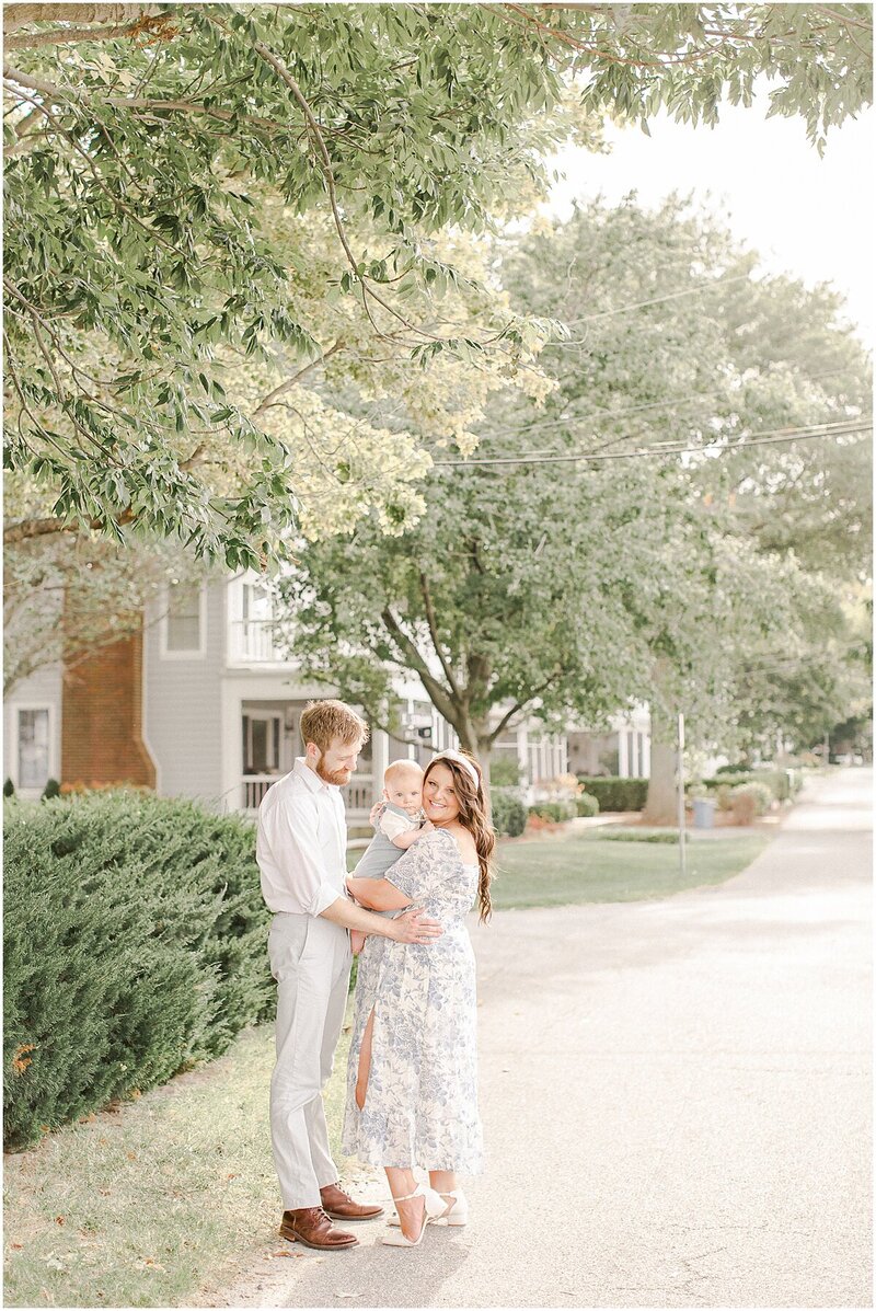 Mom and Dad snuggling baby boy outside at their maryland family session