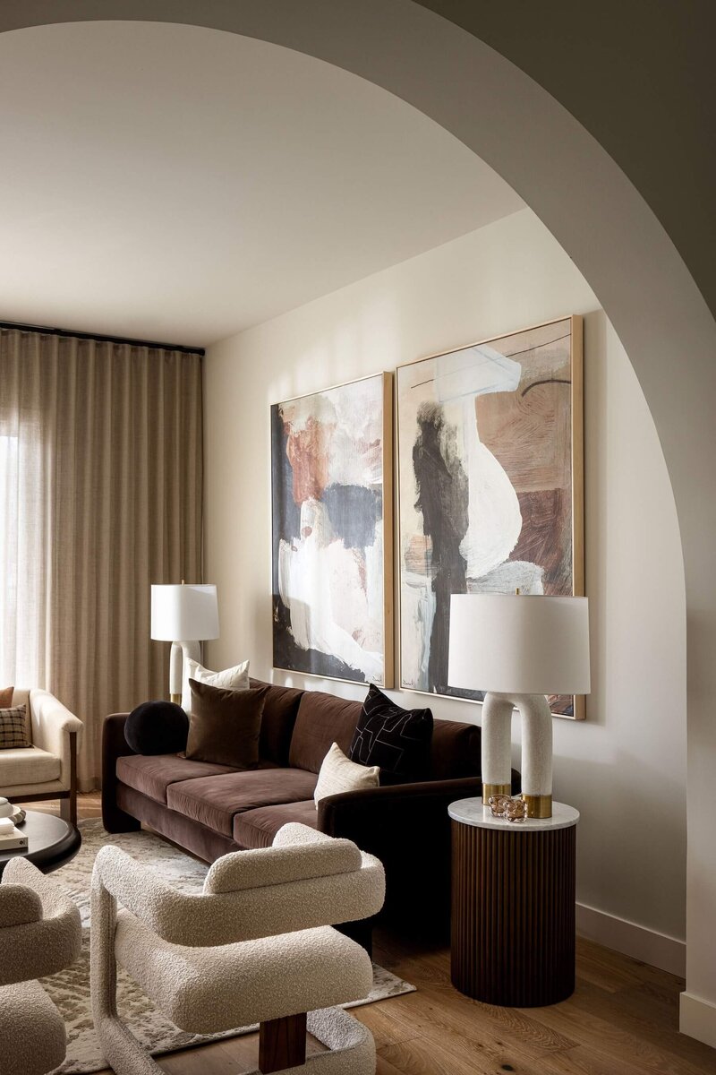 Arched living room with oversized abstract art with cocoa rich velvet tones and an elegant feel. 
