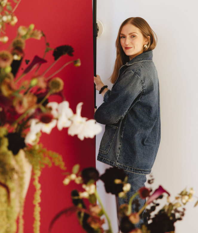 The founder of The Studio Chicago setting up a red-backdrop for a seasonal photoshoot in her studio space.