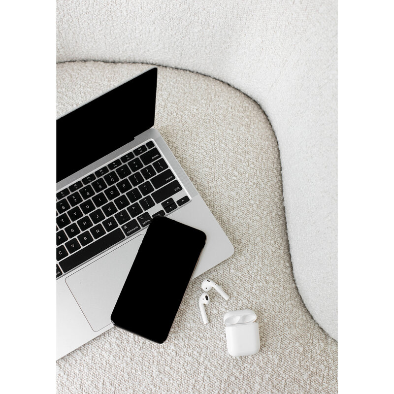 laptop on a fabric chair with an iphone