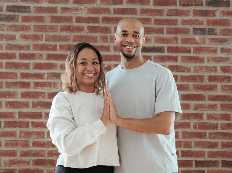two BIPOC yoga hand in hand