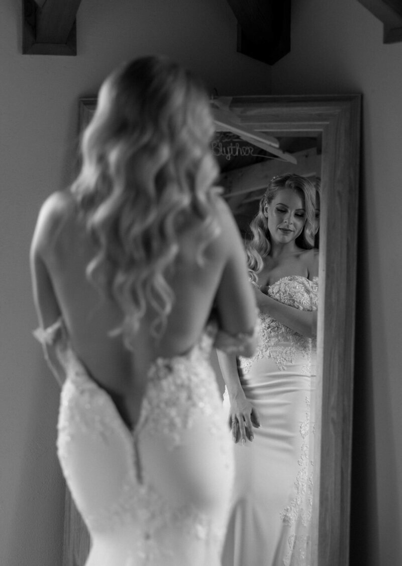 Bride fixing herself in front of the mirror