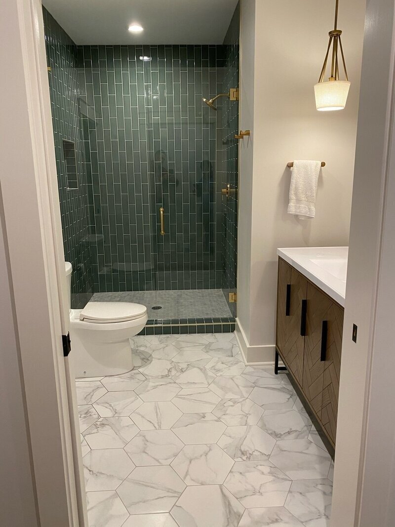 bathroom with green shower tile and luxury flooring to show atlanta ga home remodeling by Varilko Remodeling