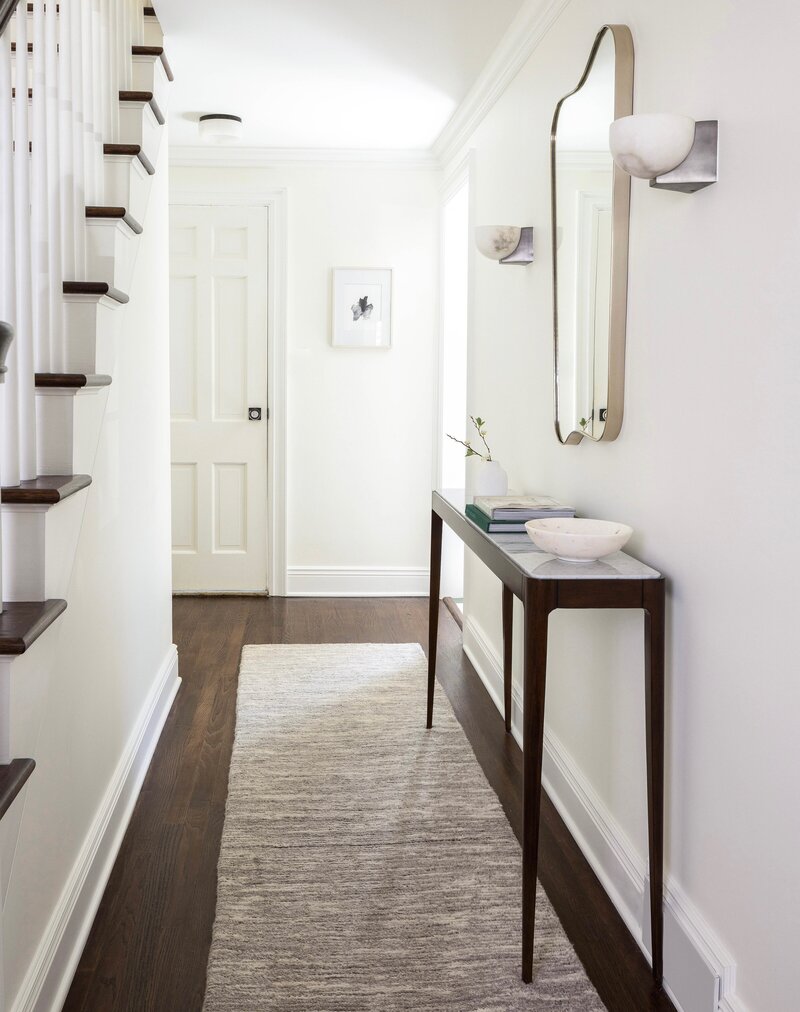 Bright, welcoming hallway with custom millwork, organic textures, and curated decor — modern entryway design in Montclair, NJ