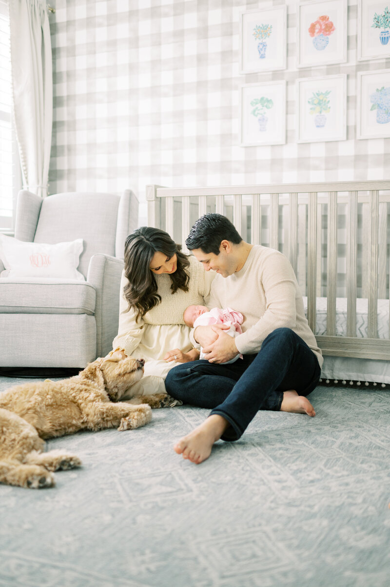 Mom and dad with newborn baby and dog in Nashville nursery