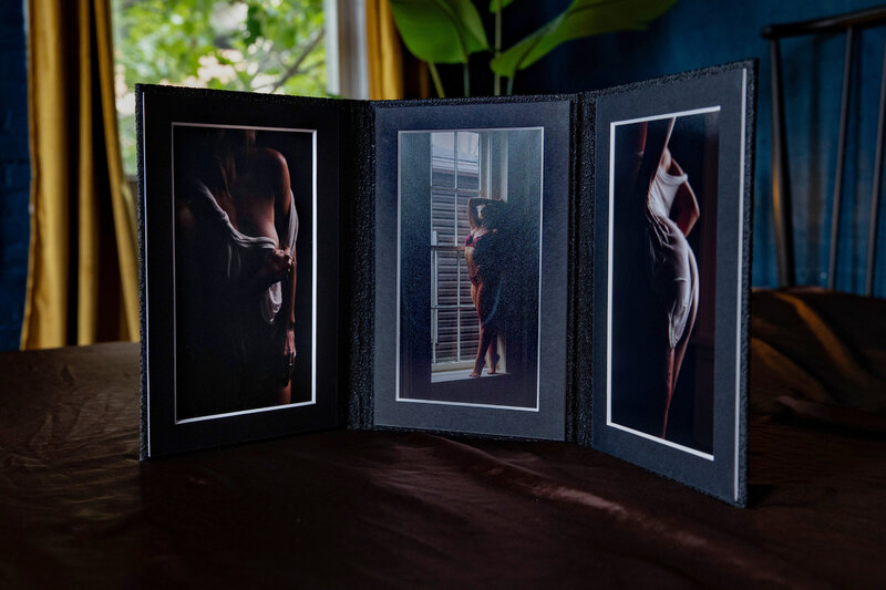 Details of a boudoir session album open on a table in a studio