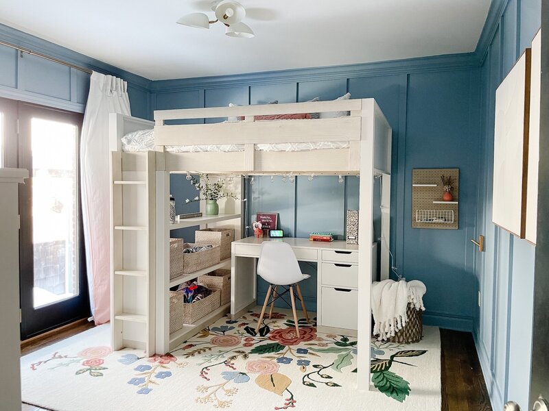 White bunk beds and a bright and colorful rug