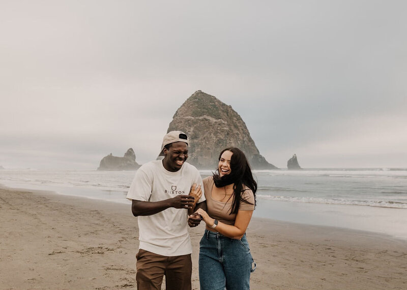 Brooke and David Pitchford laughing together while standing in front of haystack rock