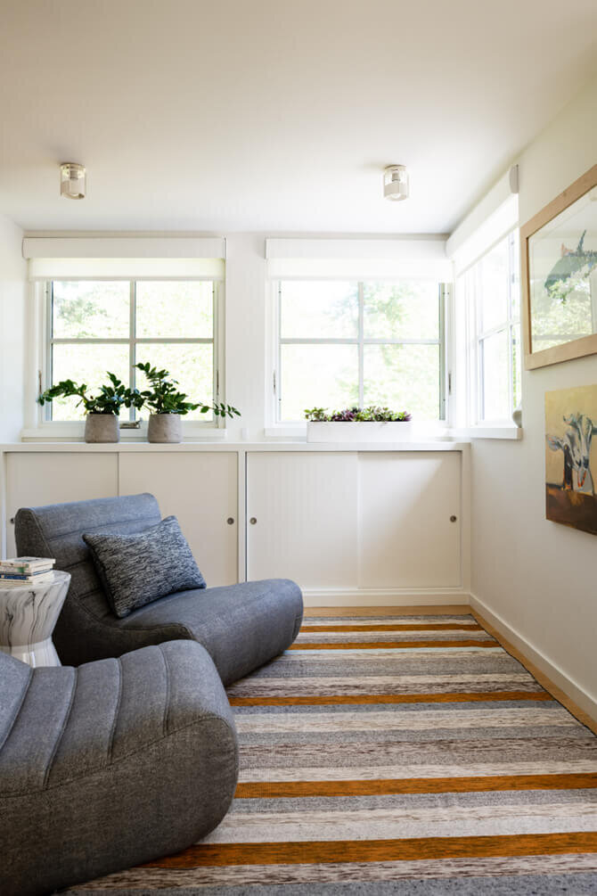 Top Interior Designers in Boston designed a cozy reading nook in a modern Hingham home, featuring built-in seating, custom cushions, and natural light.