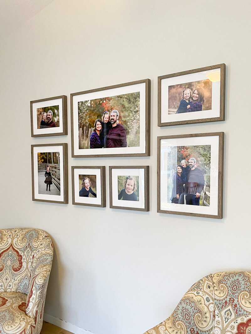 Wall gallery of 7 framed portraits on wall in Eagle home from family pictures with photographer Tiffany Hix