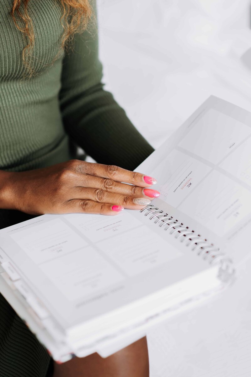 Woman holding a planner in a green blouse