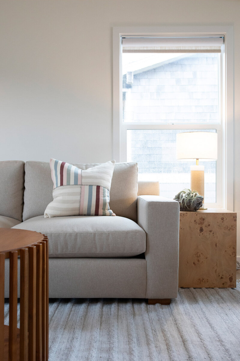 A custom living room couch in a short term rental, representing a remodel and design by Winsome Home Interiors. 