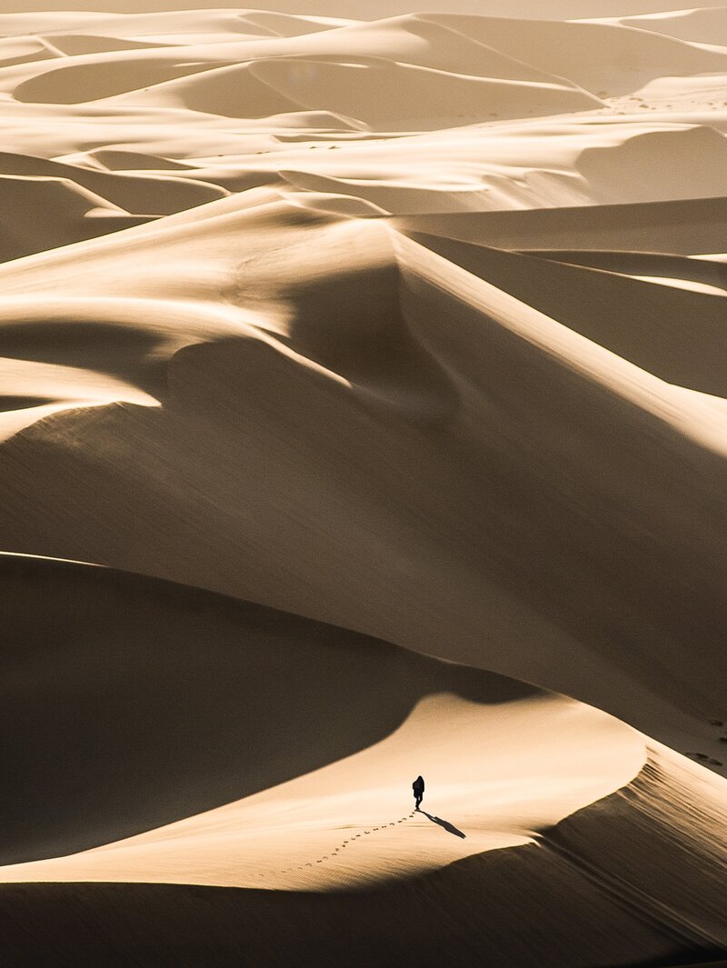 Voyageur marchant dans les dunes d'un désert