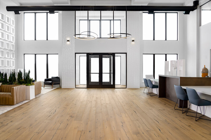 Entryway for a luxury multi-unit residence with light wood floors and leather seating by Gracious Home Interiors near Charlotte NC