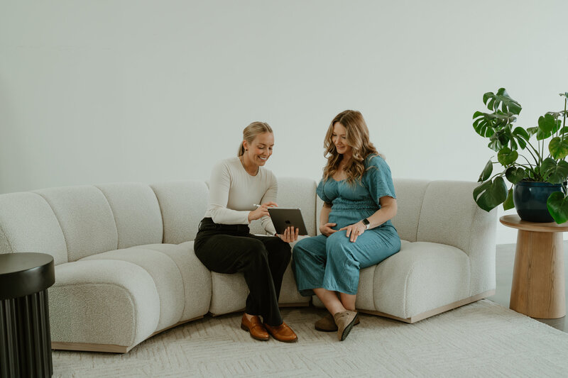 pregnant woman smiling learning about her chiropractic options 
