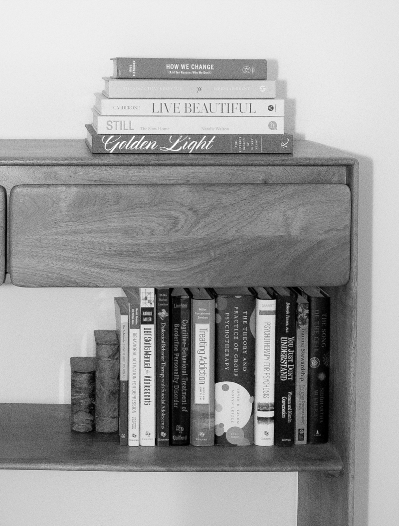 Psychology books on book shelf. Books about addiction, DBT, trauma, relationships. Other books called Golden Light, Live Beautiful, Still, How We Change