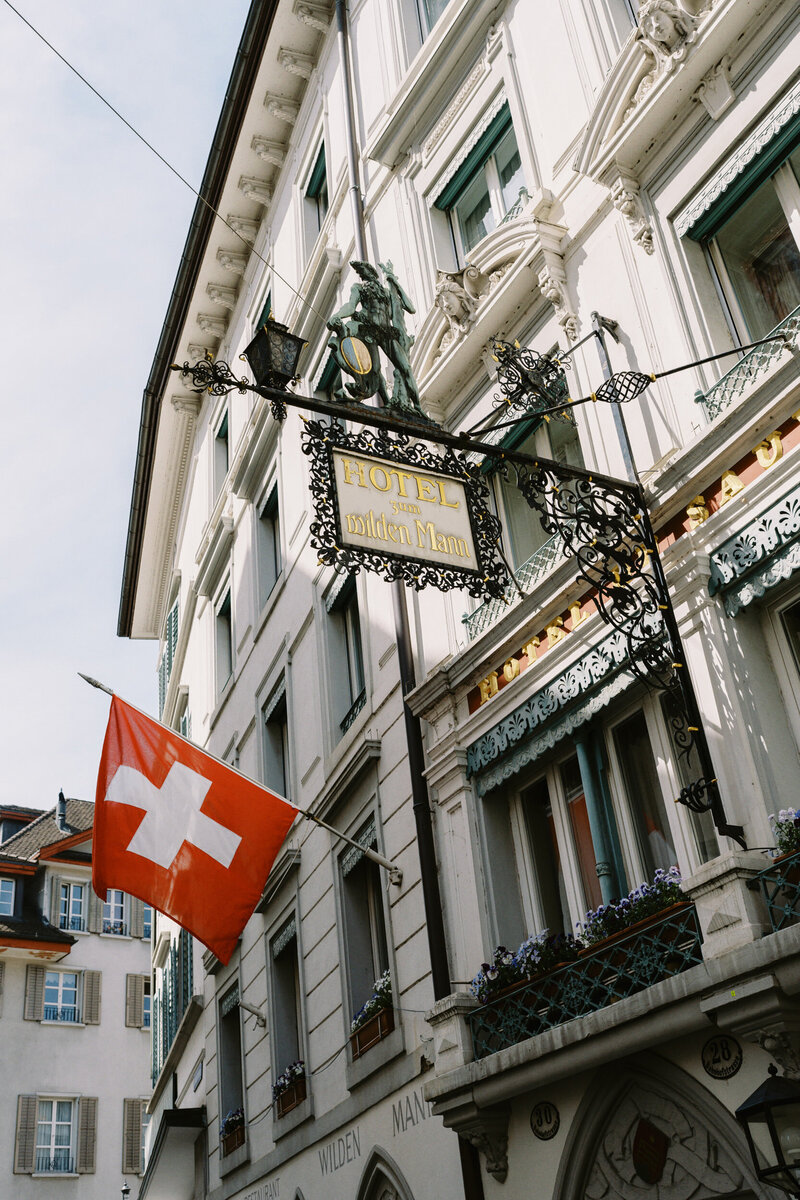 Swiss flags hang off a building in the town of Lucerne during an engagement session.