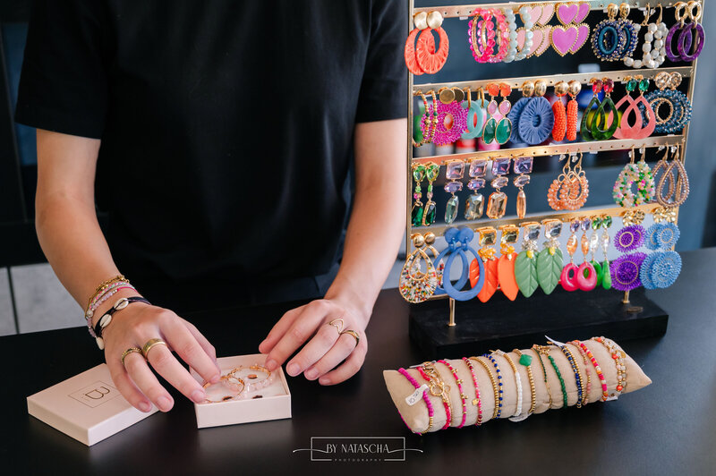 Medewerker heeft sieraden op de balie om in te pakken voor een klant