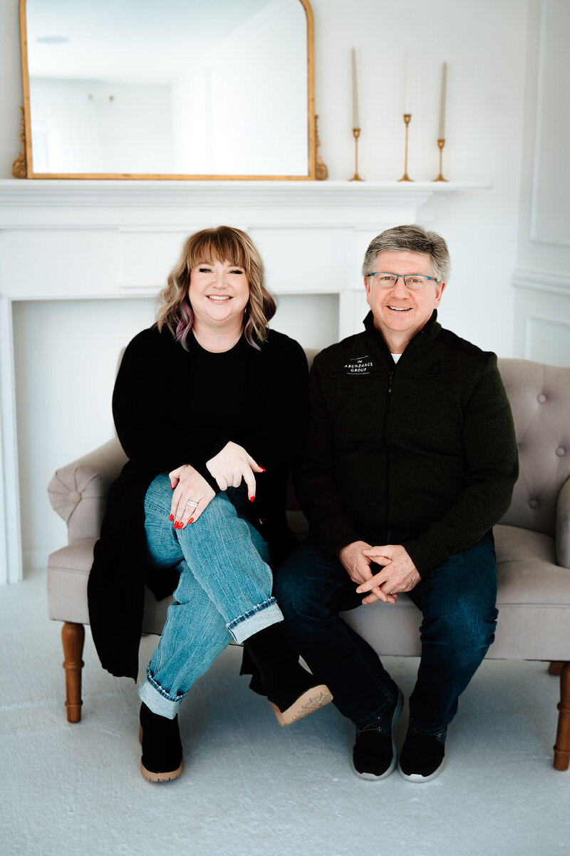 Ashley Ebert and Dale Henry smile for photo on a settee