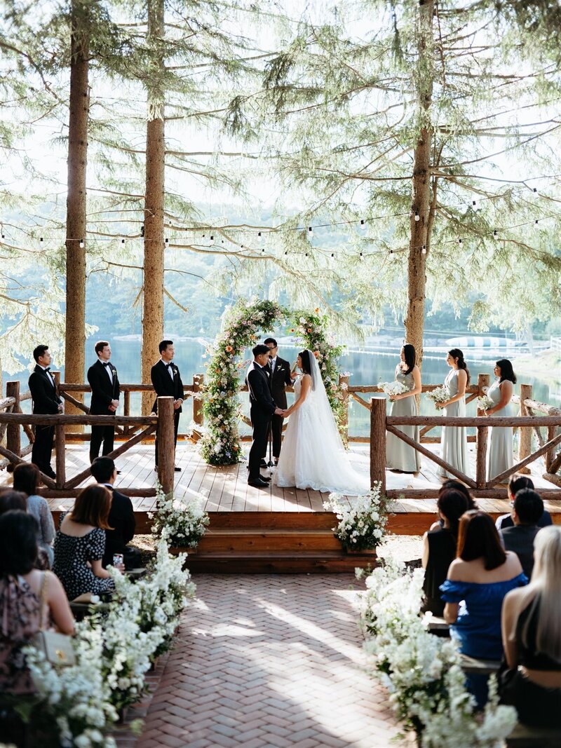 Cedar Lakes Estate wedding ceremony  under pine trees overlooking lake in Hudson Valley