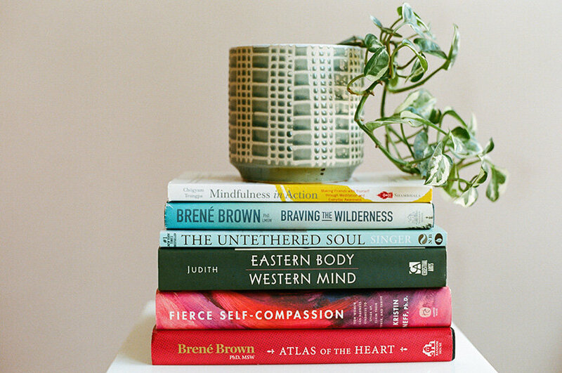 A stack of books related to therapy, featured in a therapist newsletter.