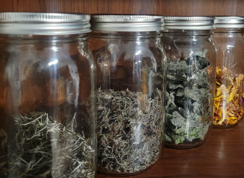 Jars of dried herbs that are used in the making of Berry and Balm handmade soap products