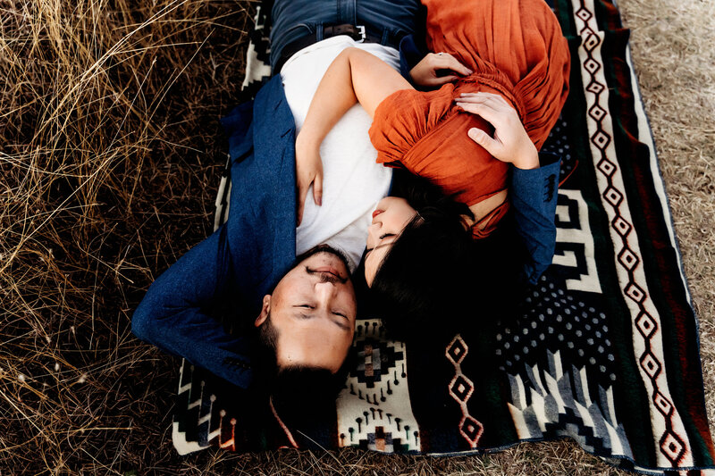 Couples Photographer, Man and woman laying down on a blanket