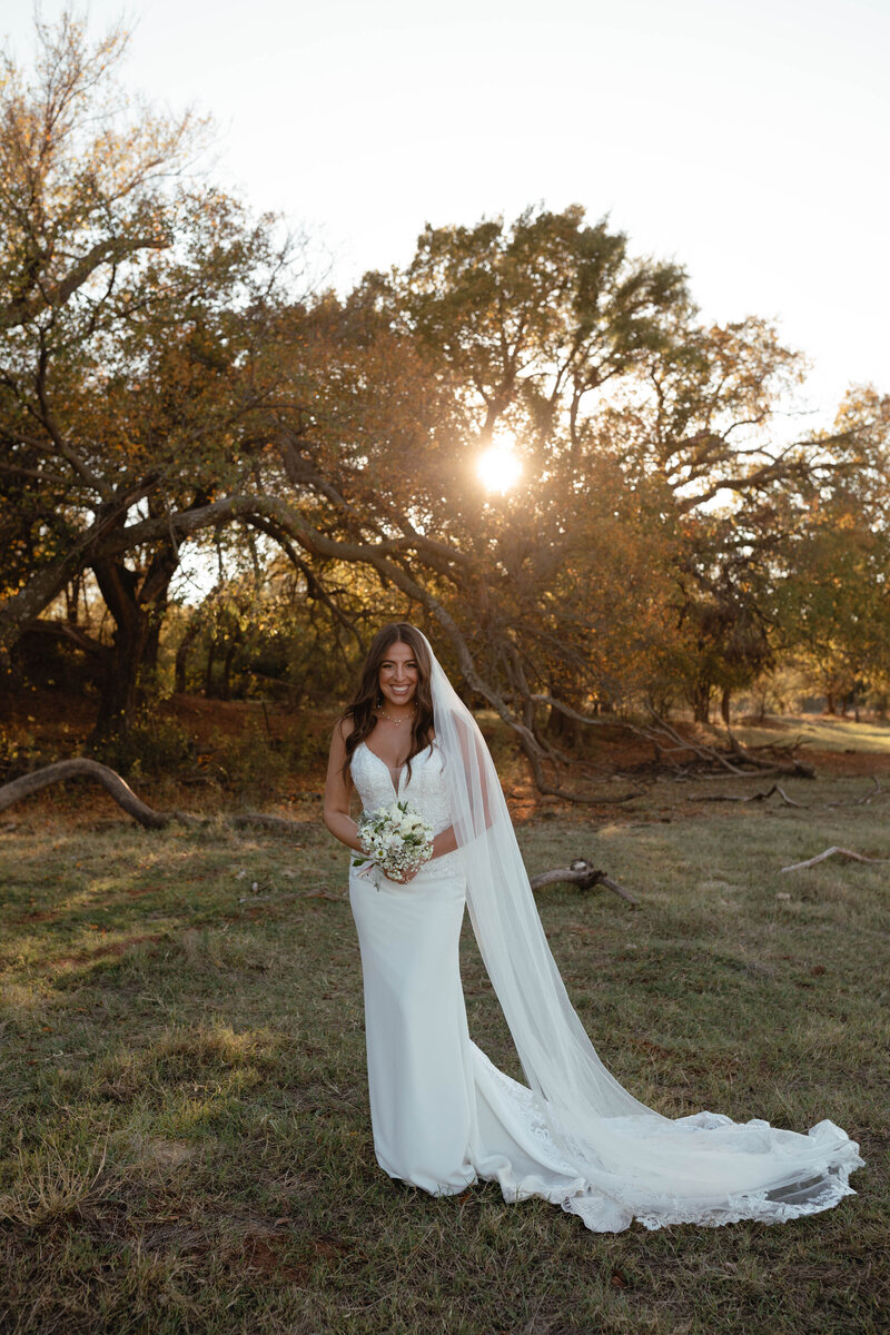 bride posing by trees