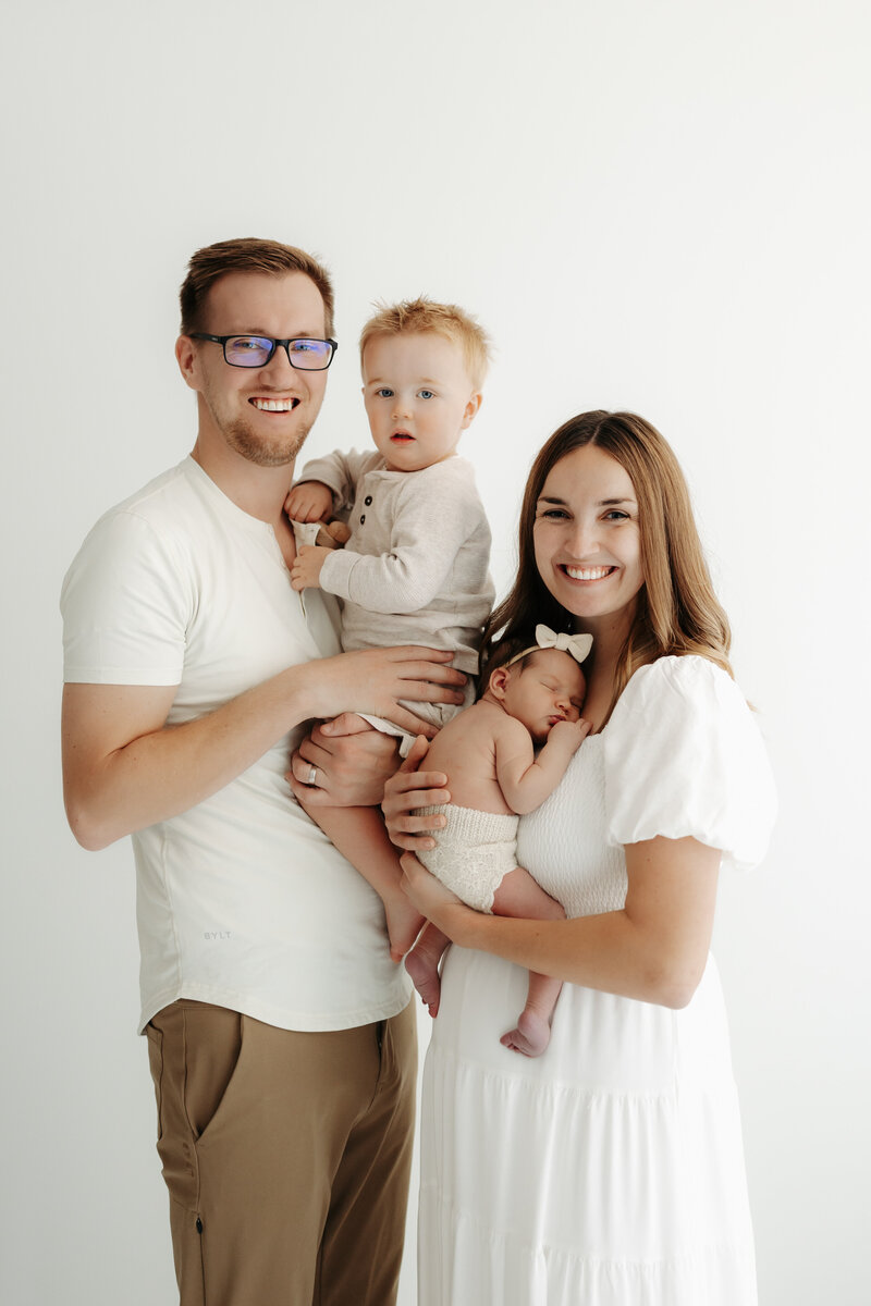 new family sitting in nursery with dog