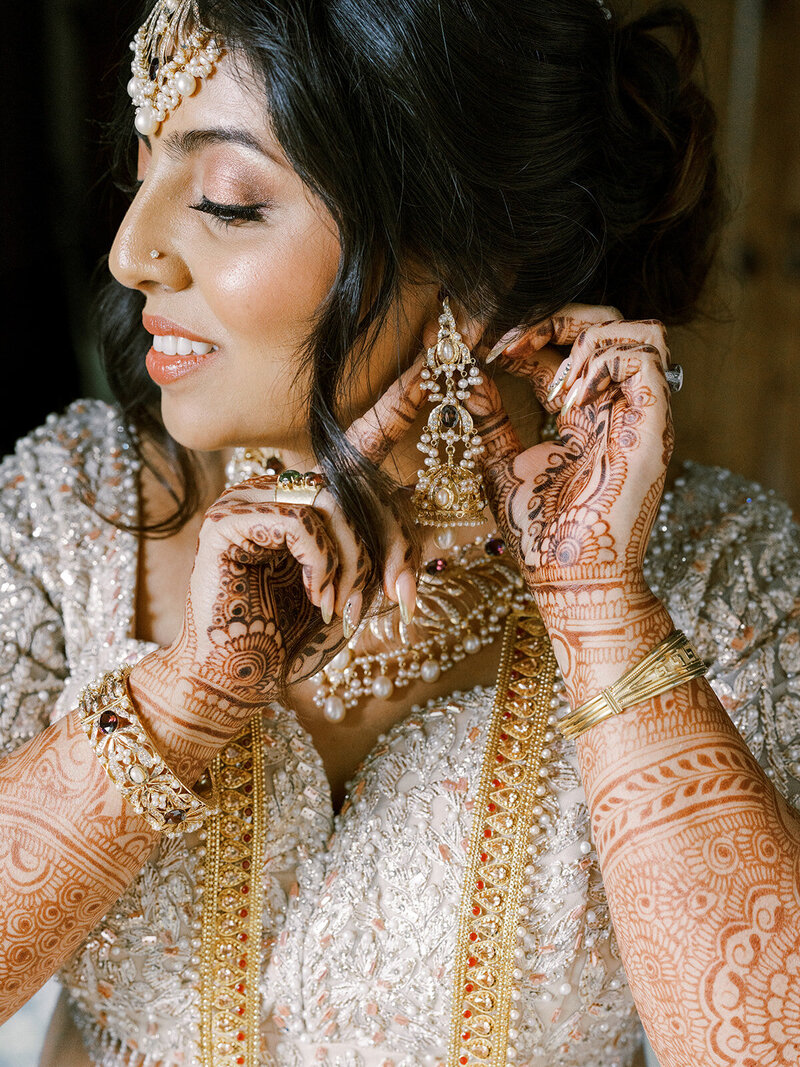 Indian wedding and San Luis Obispo, as Bride puts on her golden jewelry