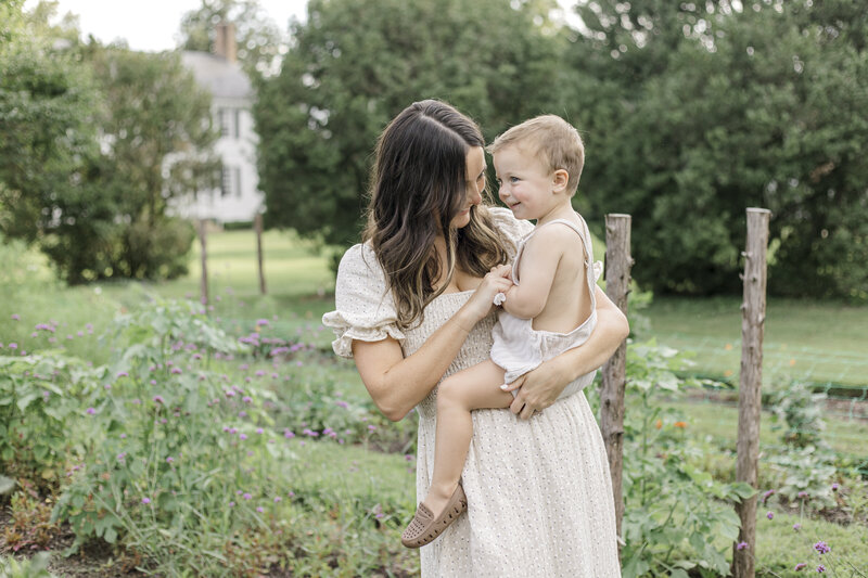 Mother holding young son in a garden