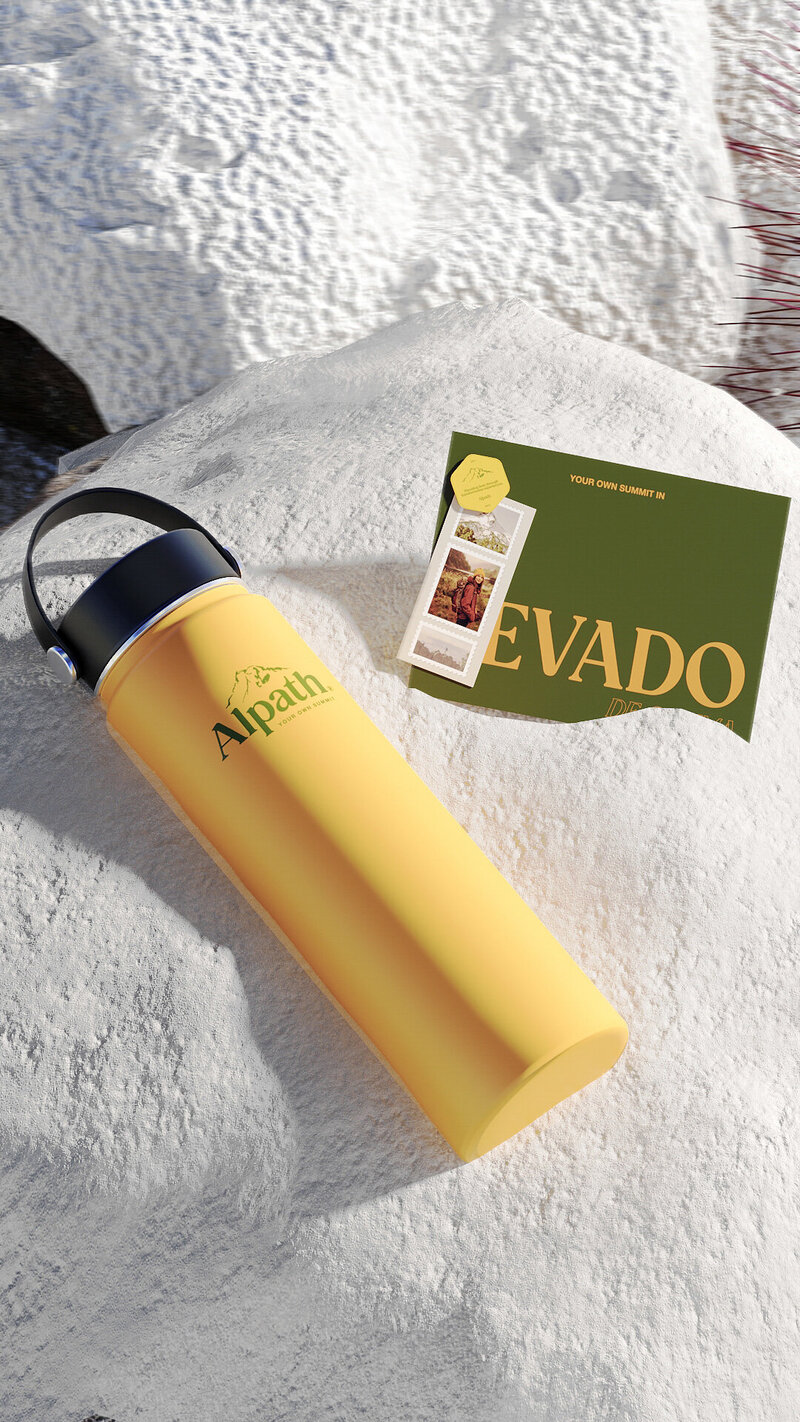Alpath outdoor brand water bottle and printed postcard resting on snowy surface, showcasing bold packaging and adventure-driven brand identity.