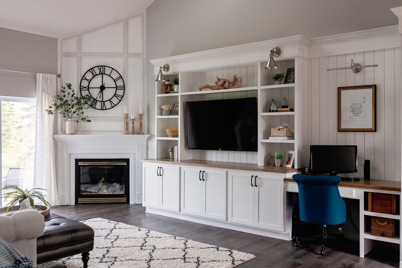 Living room design with white cabinets and a a leather ottoman.