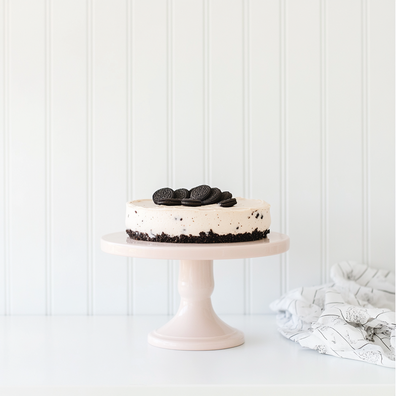 kdurski_86694_an_oreo_crusted_cheesecake_on_a_blush_cake_stand__1e4ae175-5d2c-41f1-bb36-1761522df3aa