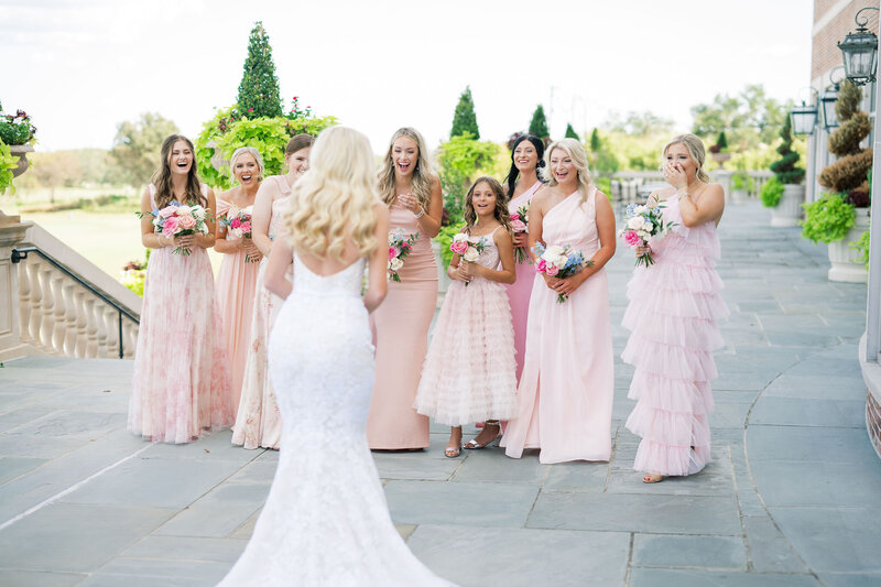 Bride and groom kissing while bridal party cheers around them