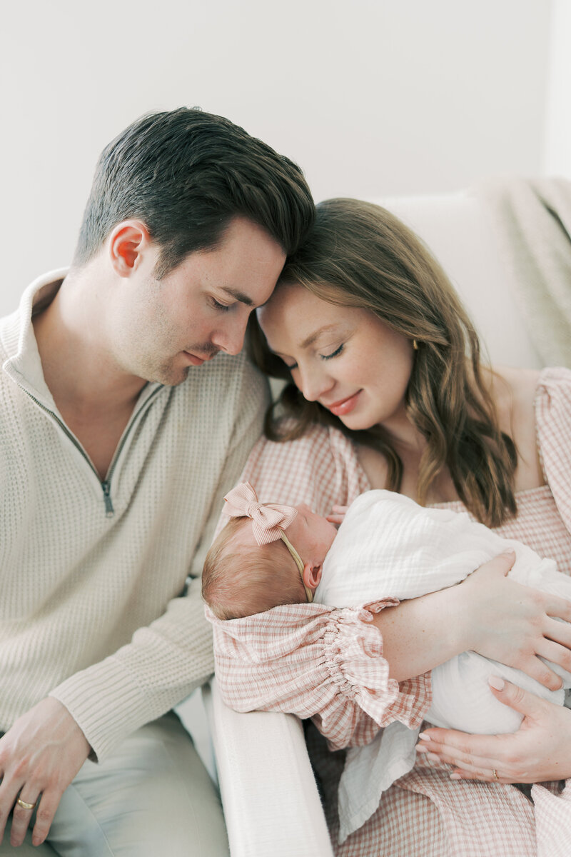 mom and dad snuggling baby girl