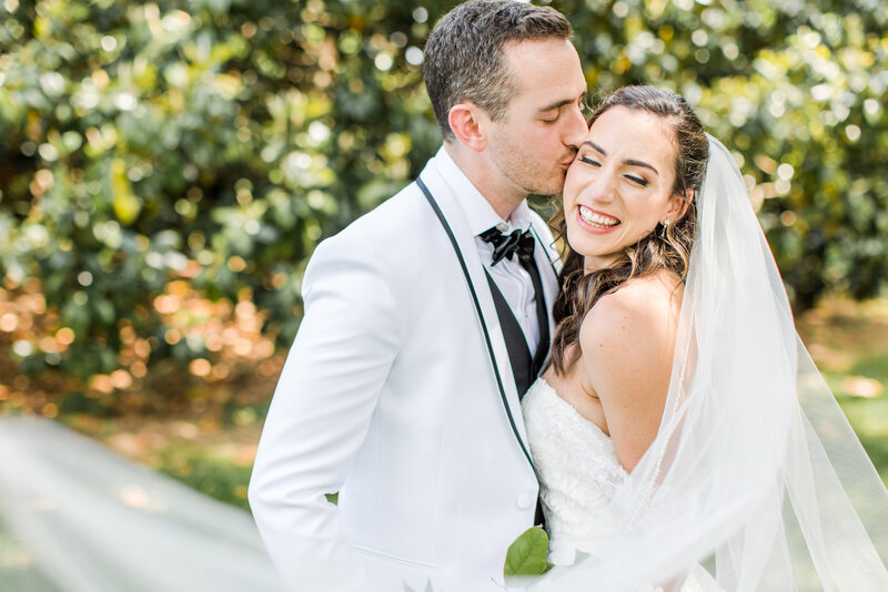 groom gives bride a kiss on cheek