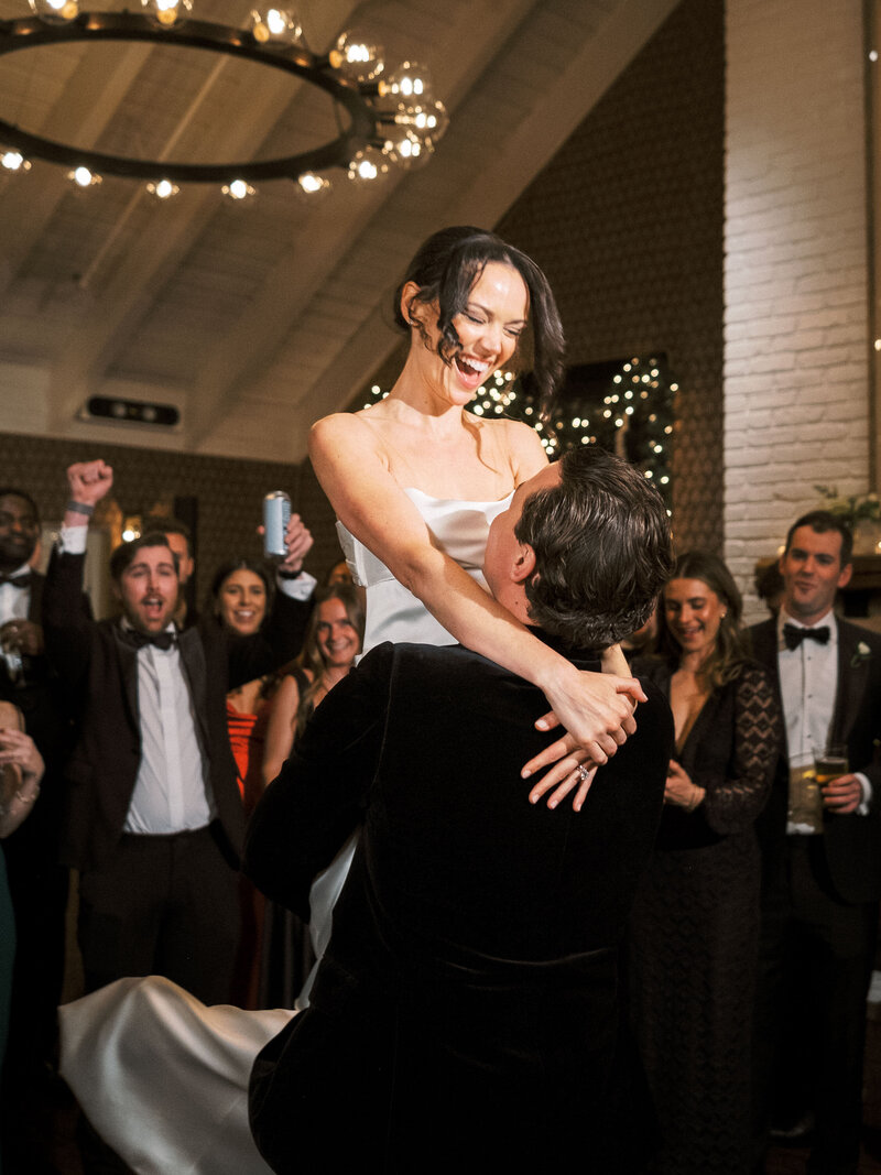 Bride being picked up during first dance