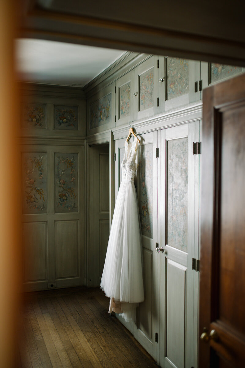 wedding dress hanging on old hand painted built in closet cabinetry in villa terrace in milwaukee wisconsin