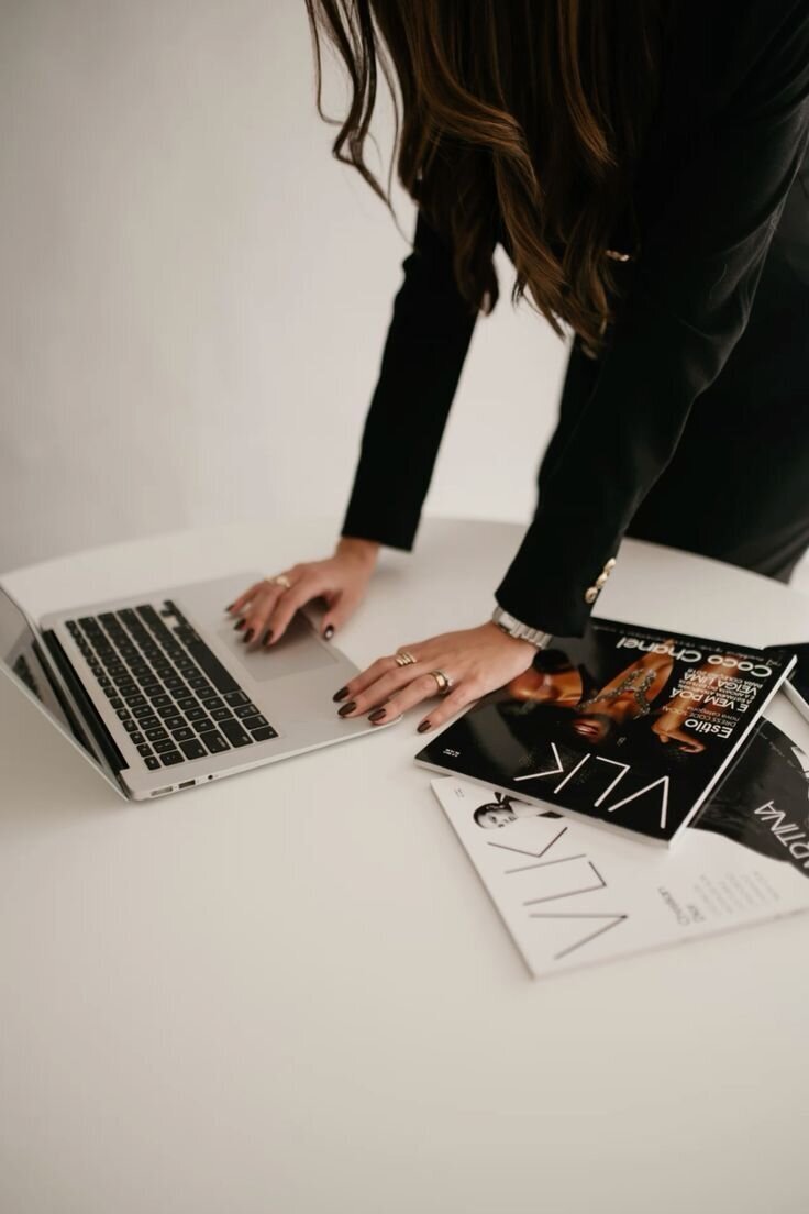 Creative professional at work with laptop and magazines, capturing behind-the-scenes of SA Communications PR agency lifestyle