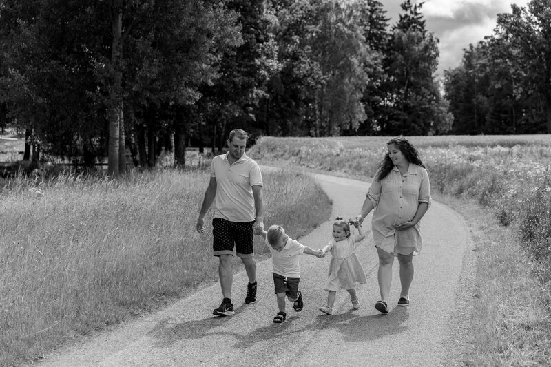 Schwarz weiss Bild von Familie wie sie Hand in Hand auf einer Strasse gehen