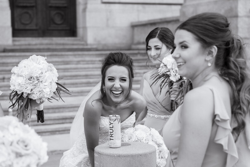 bride and her bridesmaids shares laughs and memories on her wedding day, behind an old Courthouse located in Ohio. Photographed by Aaron Aldhizer