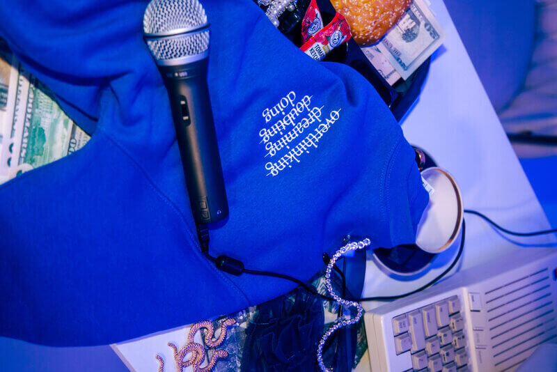 Microphone saying on a blue jumper on a messy desk