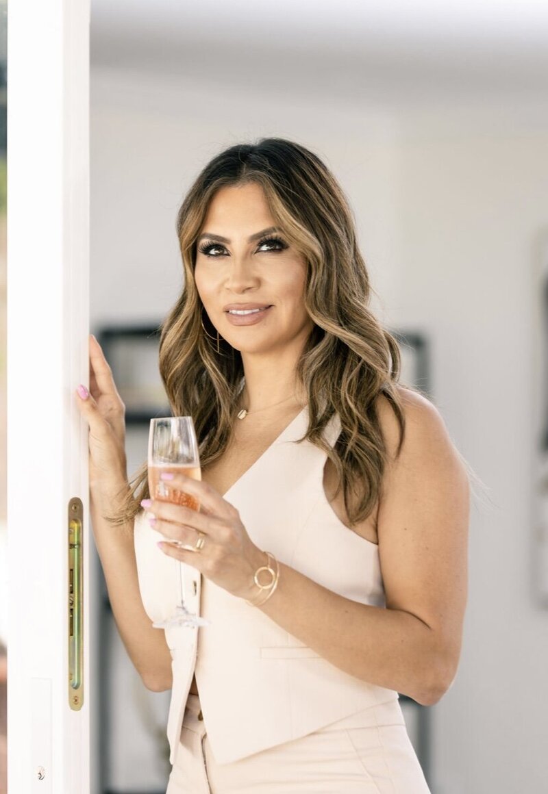 Mayra Menjivar, founder of Warrior Woman, holding a glass of champagne